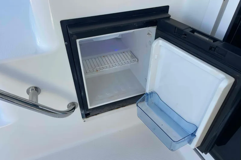 Beira Mar Yacht Photos Pics Open mini fridge on 2005 Sea Ray 420 Sedan Bridge yacht, showing interior shelving.