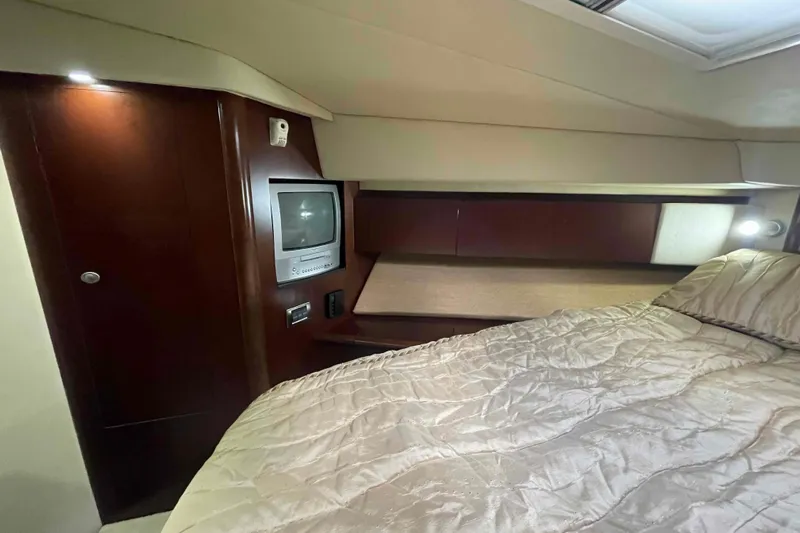 Beira Mar Yacht Photos Pics Luxurious cabin interior of 2005 Sea Ray 420 Sedan Bridge yacht with TV and cozy bedding.