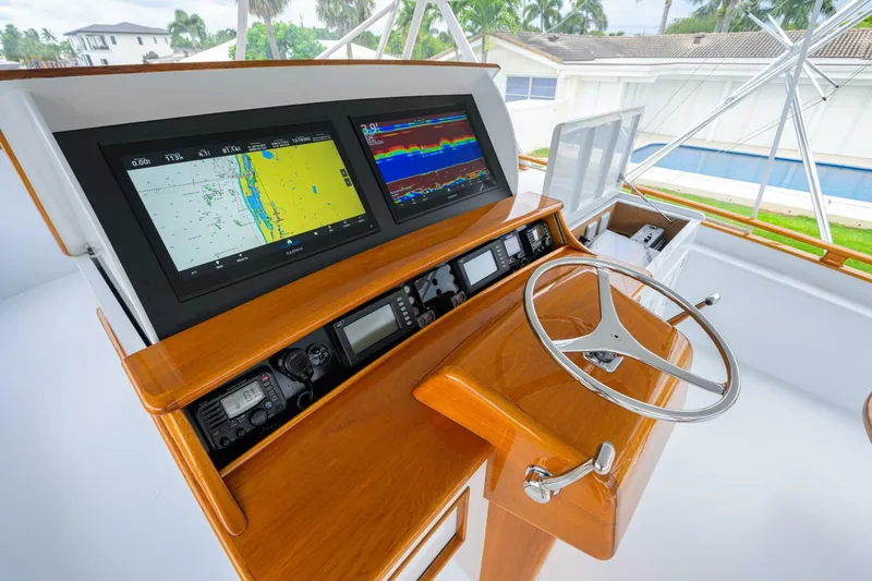 Pescaria Yacht Photos Pics 2009 Rybovich Custom Convertible yacht helm with navigation screens and wooden steering wheel.