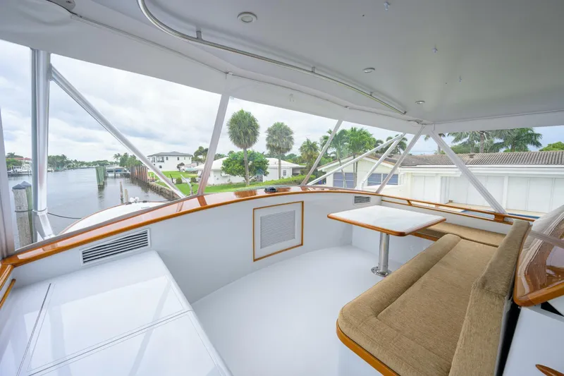 Pescaria Yacht Photos Pics 2009 Rybovich Custom Convertible yacht deck with seating and table, overlooking waterfront homes.