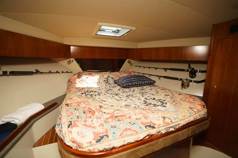 Hi Ho Silver Yacht Photos Pics Luxurious cabin interior of 2011 Rampage 41 Express yacht with cozy bed and fishing rods.