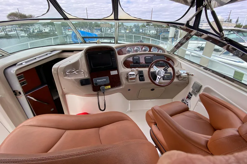 Wild Card Yacht Photos Pics 2004 Sea Ray 380 Sundancer helm with leather seats and modern navigation equipment.