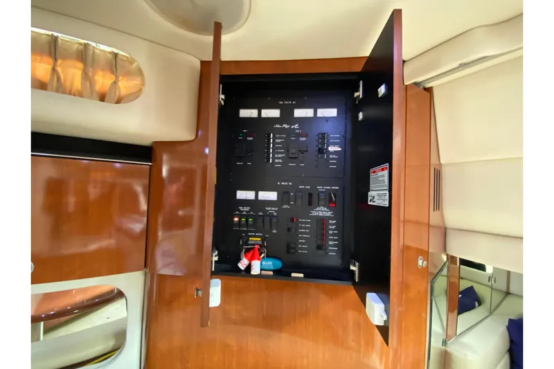 Wild Card Yacht Photos Pics Electrical panel inside 2004 Sea Ray 380 Sundancer yacht, featuring wood cabinetry and modern controls.