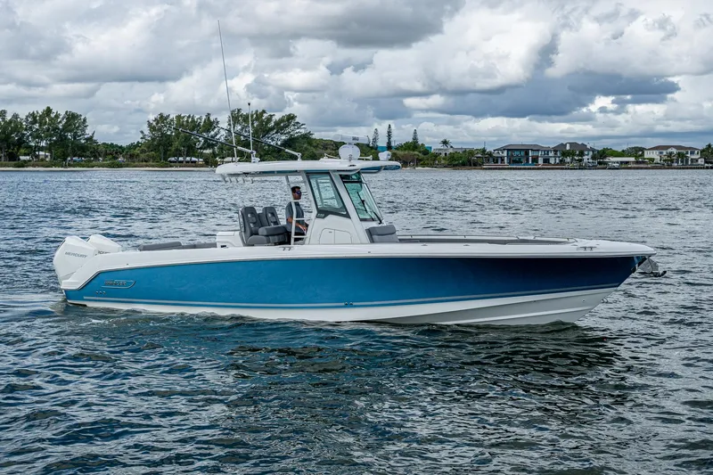  Yacht Photos Pics 2023 Boston Whaler 330 Outrage boat cruising on a scenic waterway.