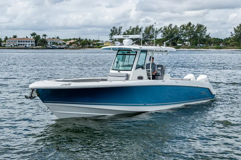 Yacht Photos Pics 2023 Boston Whaler 330 Outrage boat cruising on a calm waterway.