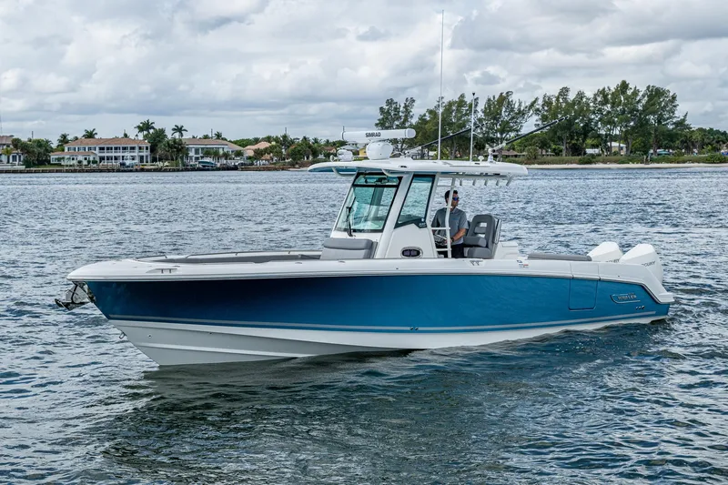  Yacht Photos Pics 2023 Boston Whaler 330 Outrage boat on calm water, showcasing sleek design and modern features.