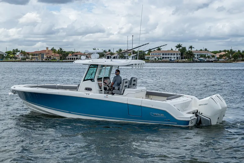  Yacht Photos Pics 2023 Boston Whaler 330 Outrage boat cruising on a calm waterway.