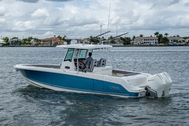  Yacht Photos Pics 2023 Boston Whaler 330 Outrage boat cruising on a calm waterway.