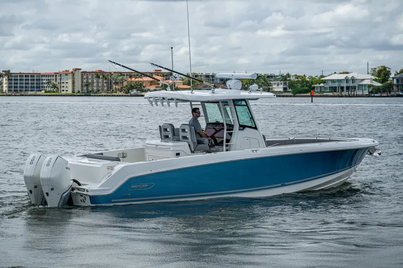  Yacht Photos Pics 2023 Boston Whaler 330 Outrage boat on calm water, featuring sleek design and dual engines.
