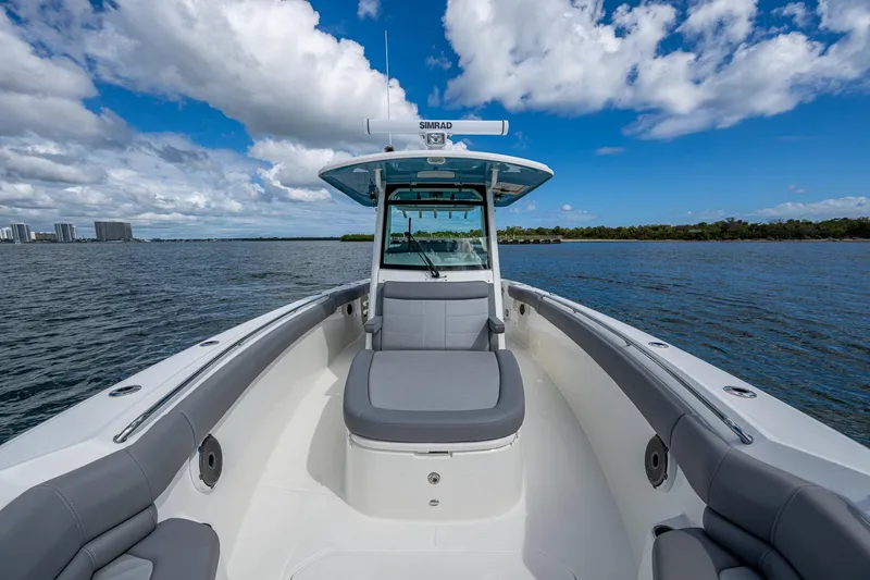  Yacht Photos Pics 2023 Boston Whaler 330 Outrage boat on open water under blue sky.