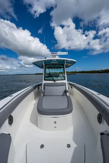  Yacht Photos Pics 2023 Boston Whaler 330 Outrage boat on water under blue sky with clouds.
