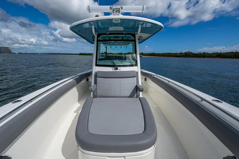  Yacht Photos Pics 2023 Boston Whaler 330 Outrage boat on calm water under blue sky.