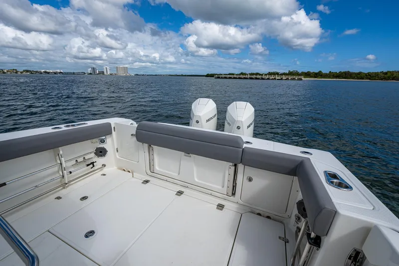  Yacht Photos Pics 2023 Boston Whaler 330 Outrage boat on calm water under a partly cloudy sky.