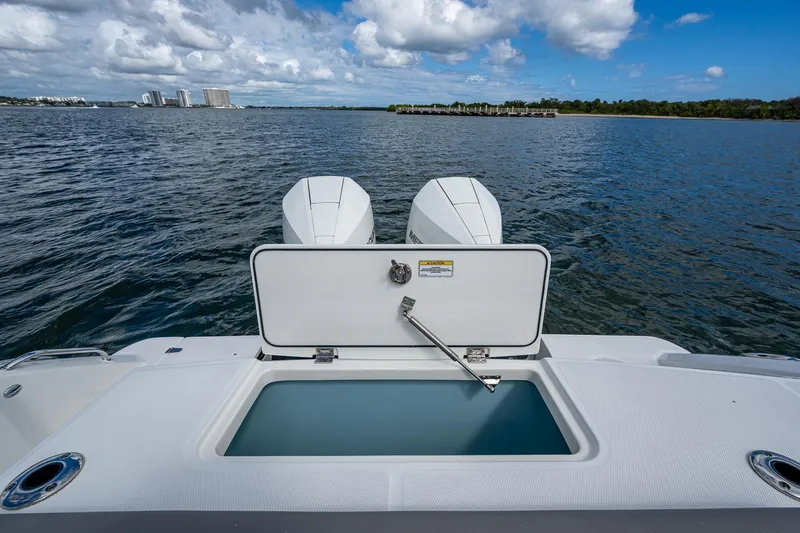  Yacht Photos Pics 2023 Boston Whaler 330 Outrage boat with open storage compartment on calm water.
