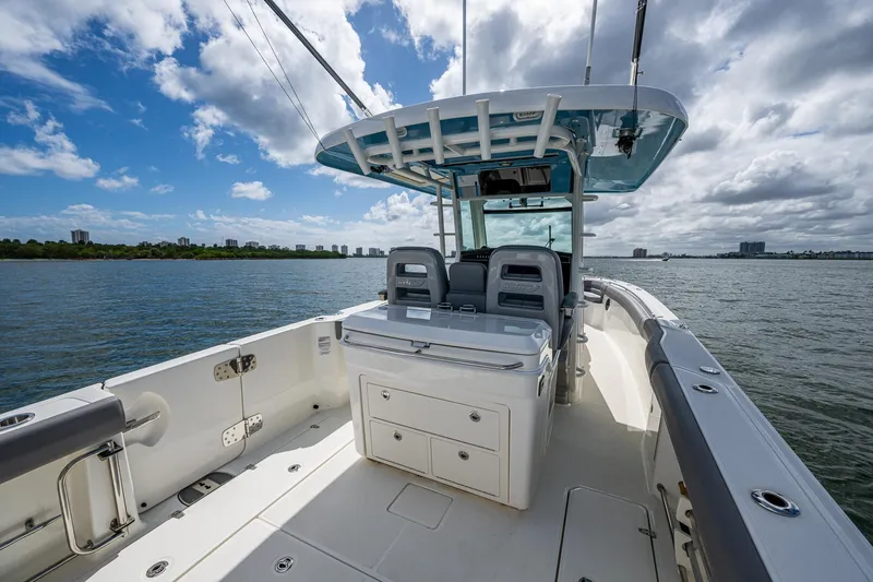  Yacht Photos Pics 2023 Boston Whaler 330 Outrage boat on calm water under a partly cloudy sky.