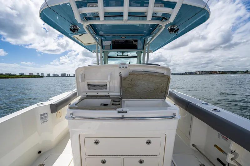  Yacht Photos Pics 2023 Boston Whaler 330 Outrage boat interior with open storage compartment on a sunny day.