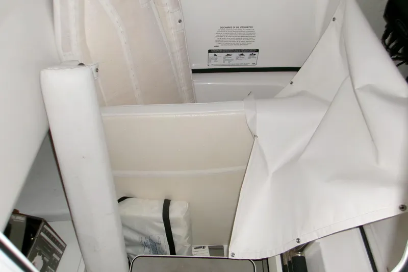  Yacht Photos Pics 2023 Sportsman Open 282 Center Console interior storage area with white fabric and equipment.