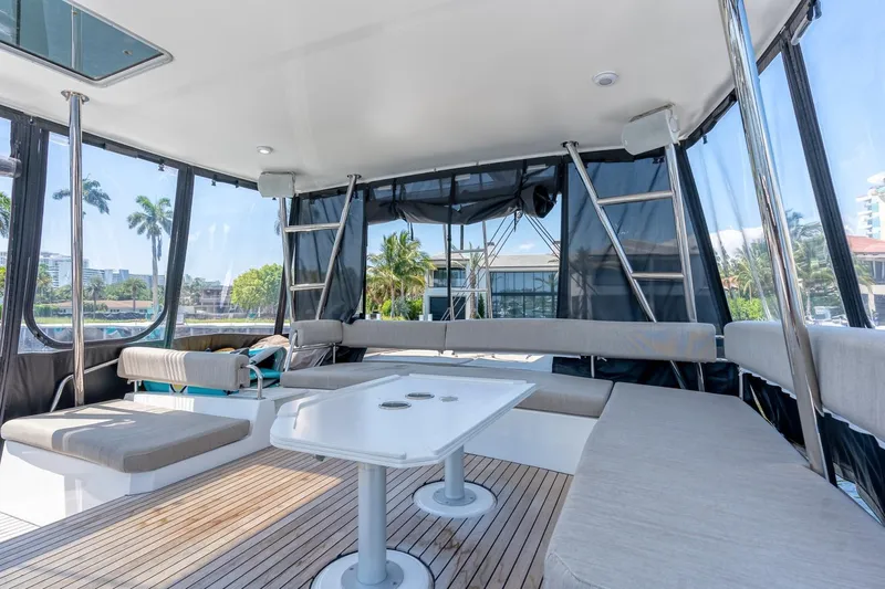 Dreamboat Annie Yacht Photos Pics Spacious interior of 2022 Bali 4.8 catamaran with seating and table, surrounded by windows.