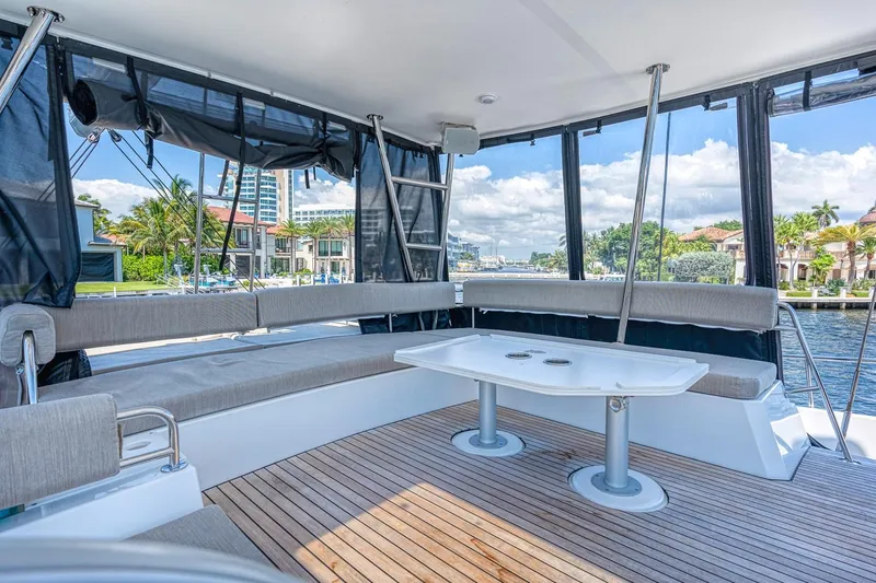 Dreamboat Annie Yacht Photos Pics Spacious deck of 2022 Bali 4.8 catamaran with seating and table, overlooking waterfront.