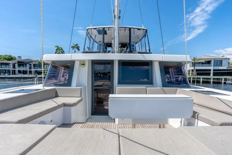 Dreamboat Annie Yacht Photos Pics 2022 Bali 4.8 catamaran with spacious deck and modern design, docked by waterfront homes.