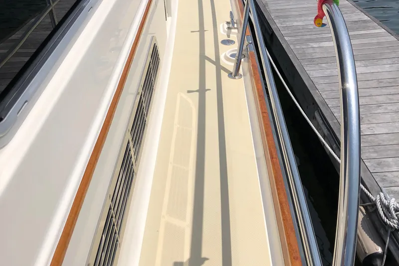  Yacht Photos Pics 2009 Sabre 40 Sedan yacht deck with railing, docked beside a wooden pier.