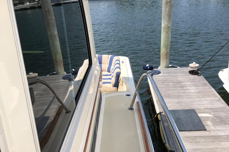  Yacht Photos Pics 2009 Sabre 40 Sedan yacht docked, featuring striped seating and polished railings.