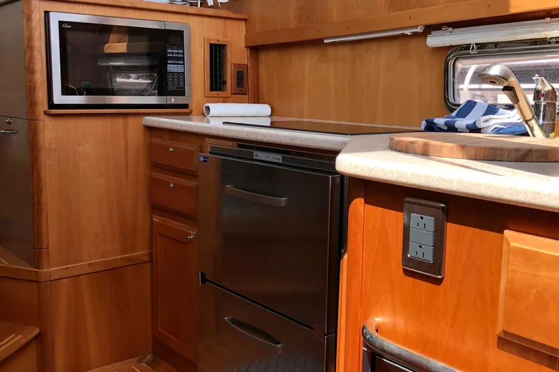  Yacht Photos Pics 2009 Sabre 40 Sedan kitchen with microwave, dishwasher, and wooden cabinetry.