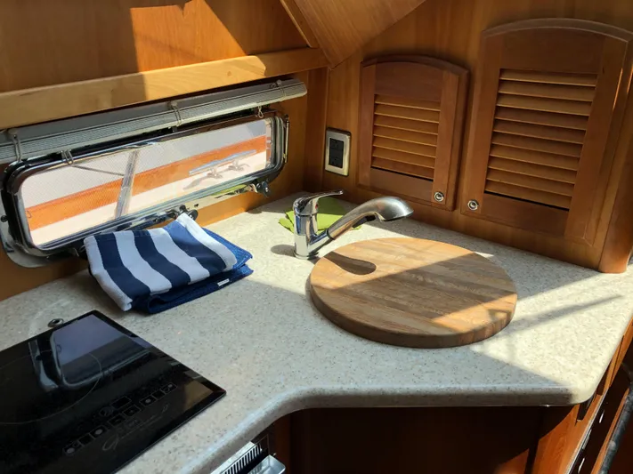  Yacht Photos Pics 2009 Sabre 40 Sedan kitchen with countertop, sink, cutting board, and striped towel.