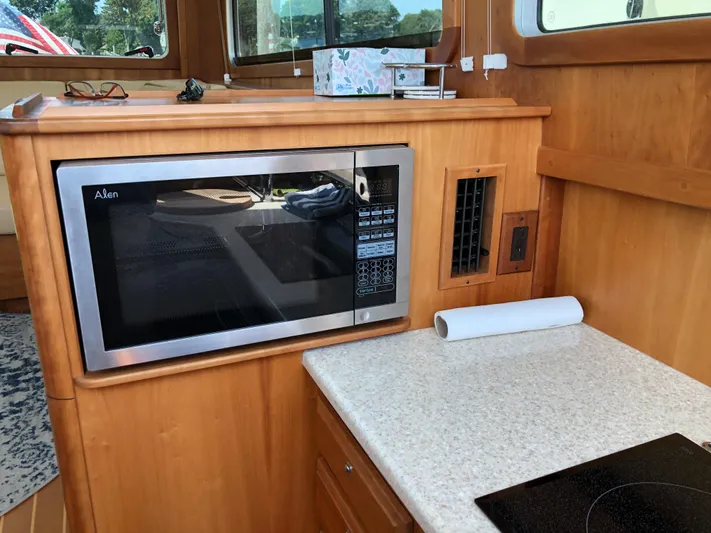  Yacht Photos Pics 2009 Sabre 40 Sedan kitchen with microwave, countertop, and wooden cabinetry.