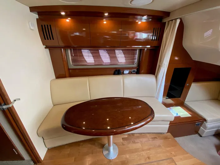 Taramina Yacht Photos Pics Interior of 2008 Sea Ray 38 Sundancer with wooden table and cream seating.