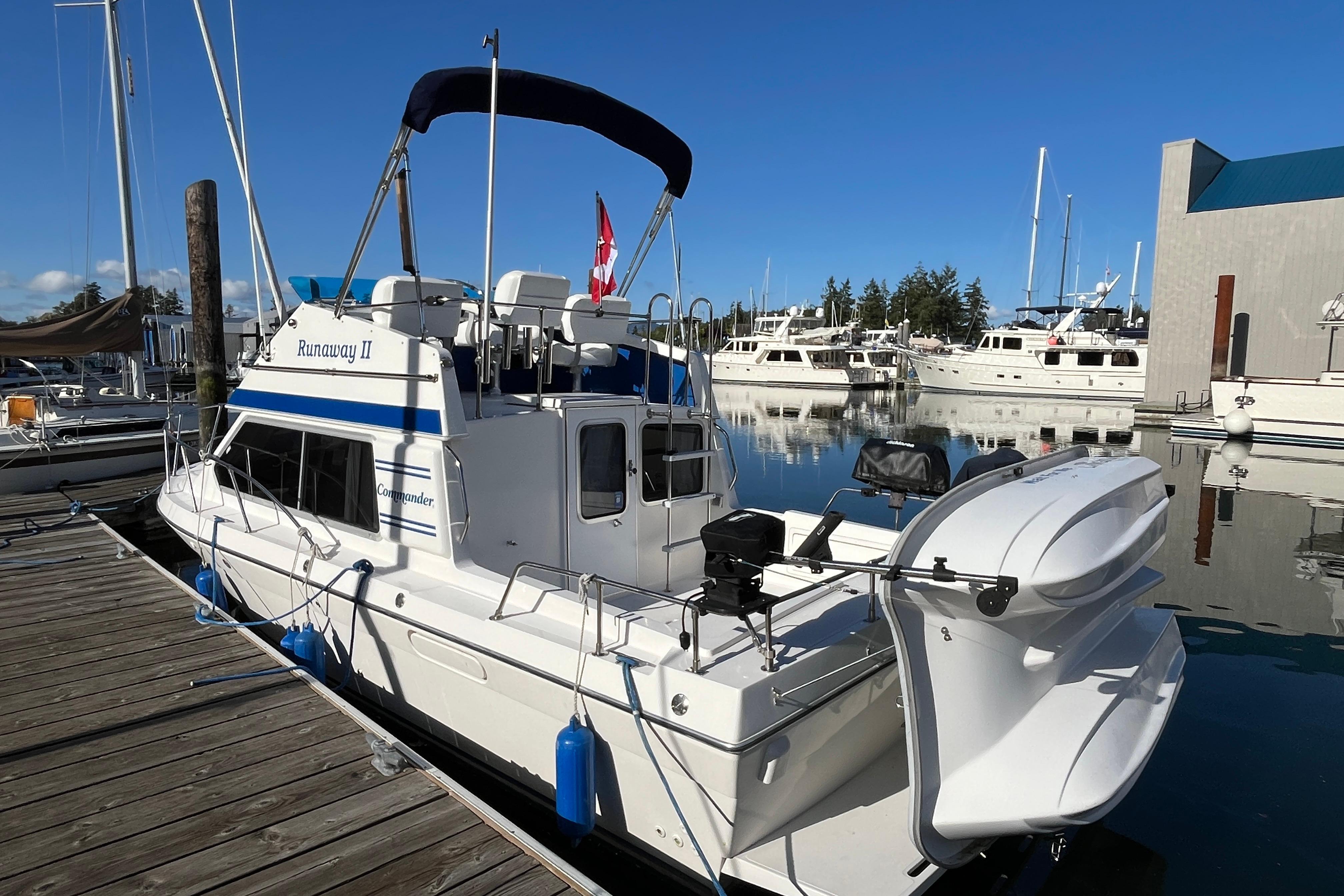 2006 Commander 26 Sedan boat docked in a marina, clear blue sky, calm water.