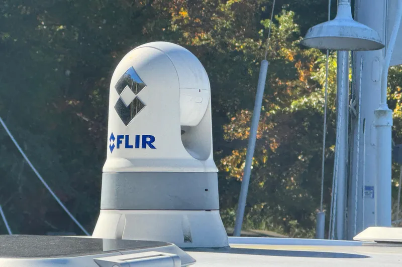 In Pursuit Yacht Photos Pics FLIR camera on 2019 Pursuit DC 325 Dual Console boat, surrounded by trees.