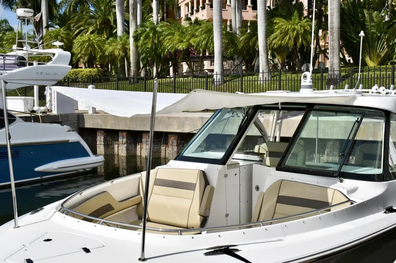 In Pursuit Yacht Photos Pics 2019 Pursuit DC 325 Dual Console boat docked near palm trees.