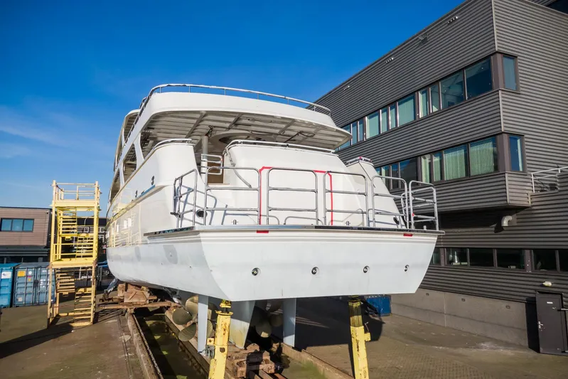 Valeria Yacht Photos Pics 1975 Feadship Motoryacht on dry dock, exterior view with blue sky background.