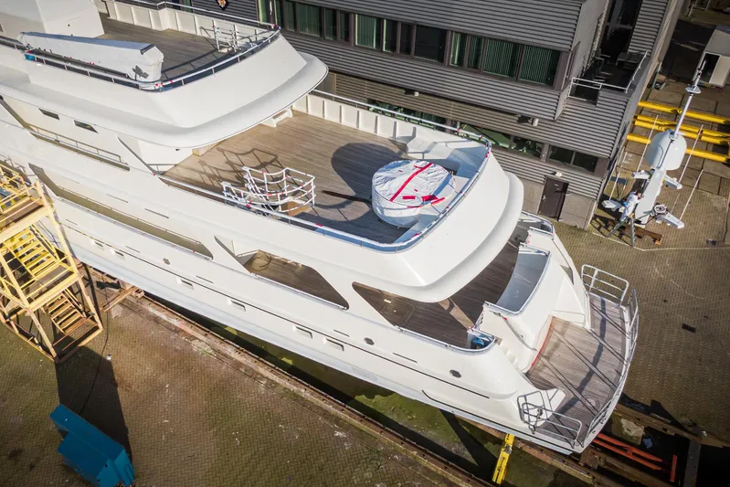Valeria Yacht Photos Pics 1975 Feadship Motoryacht in dry dock, showcasing sleek design and spacious deck.