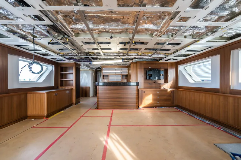 Valeria Yacht Photos Pics Interior of a 1975 Feadship motoryacht under renovation, featuring wood paneling and exposed ceiling.