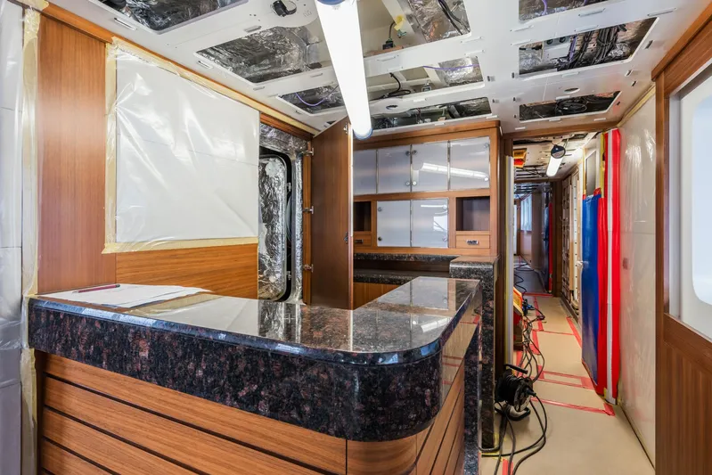 Valeria Yacht Photos Pics 1975 Feadship Motoryacht interior under renovation with wood paneling and granite countertops.