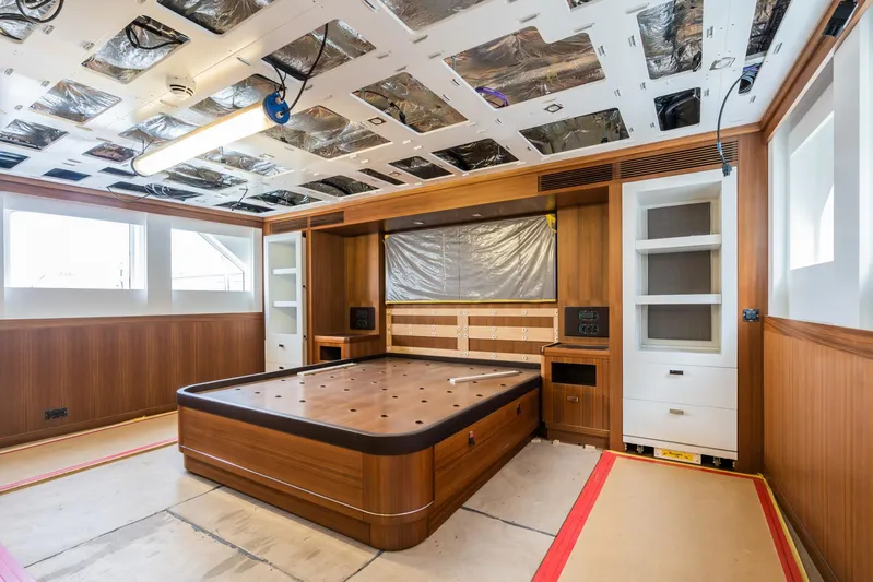 Valeria Yacht Photos Pics 1975 Feadship Motoryacht interior under renovation, featuring wood paneling and built-in shelving.