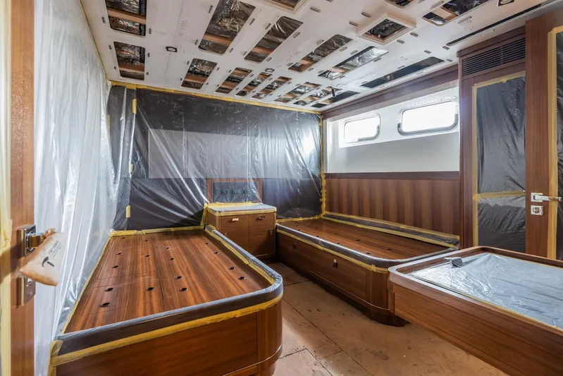 Valeria Yacht Photos Pics 1975 Feadship Motoryacht interior under renovation, featuring wooden beds and protective coverings.