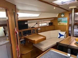 Beckon Yacht Photos Pics Interior of 2010 Jeanneau Sun Odyssey 39i Performance sailboat, featuring cozy seating and wooden finishes.