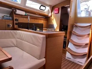 Beckon Yacht Photos Pics Interior of 2010 Jeanneau Sun Odyssey 39i Performance yacht, featuring cozy seating and wooden finishes.