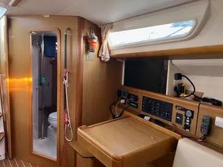 Beckon Yacht Photos Pics Interior of 2010 Jeanneau Sun Odyssey 39i Performance sailboat, featuring navigation station and bathroom.