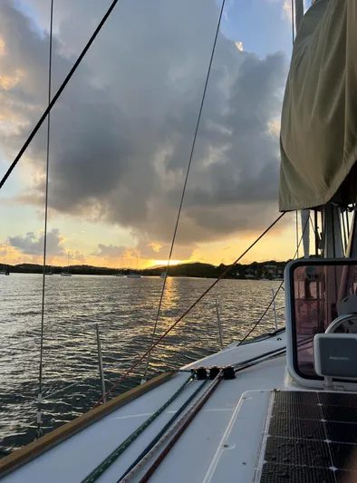 Beckon Yacht Photos Pics Jeanneau Sun Odyssey 39i sailing at sunset, 2010 model, with dramatic clouds and calm waters.