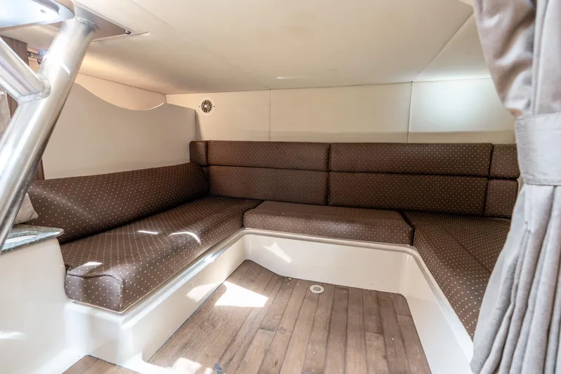 Reel Blessing Yacht Photos Pics 2012 Boston Whaler 345 Conquest cabin interior with brown cushioned seating and wood flooring.