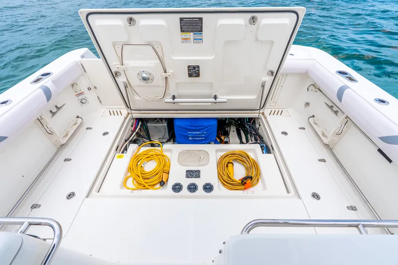 Reel Blessing Yacht Photos Pics Open storage compartment on 2012 Boston Whaler 345 Conquest boat, featuring coiled yellow cables.