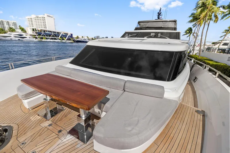 Notorious Yacht Photos Pics 2017 Sanlorenzo SL106 yacht deck with seating and table, docked by waterfront.