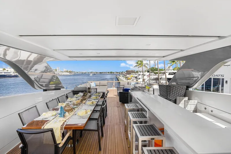 Notorious Yacht Photos Pics Luxurious 2017 Sanlorenzo SL106 yacht deck with elegant dining setup and scenic waterfront view.