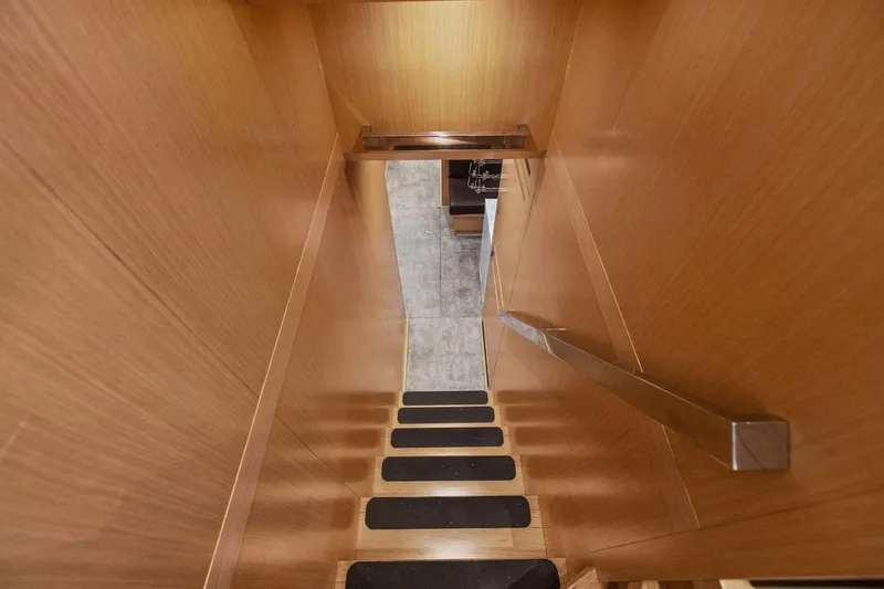 Notorious Yacht Photos Pics Staircase inside 2017 Sanlorenzo SL106 yacht with wooden walls and metal handrail.
