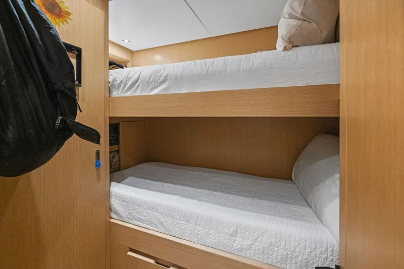 Notorious Yacht Photos Pics Bunk beds in 2017 Sanlorenzo SL106 yacht cabin, featuring wooden interior and white bedding.