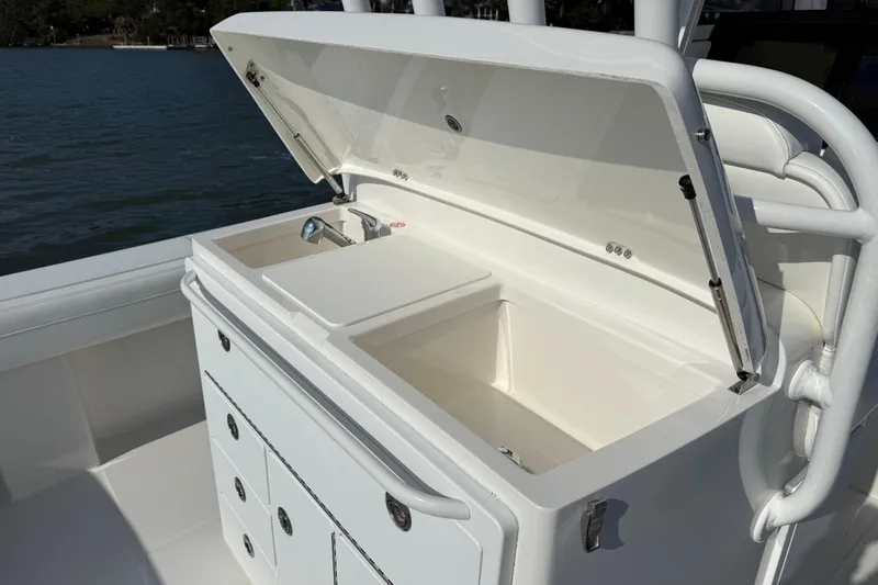  Yacht Photos Pics 2020 Regulator 31 boat with open storage compartment and sink, docked by the water.